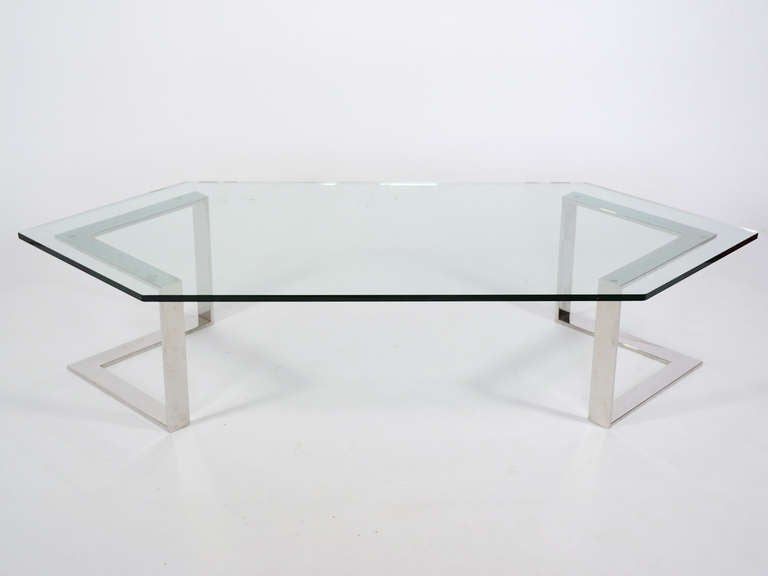 This large scale coffee table by Directional has a very strong architectural quality with a pair of chrome steel bases which support a hexagonal glass top that echos the angular shape of the bases. Likely a Milo Baughman design, the flat profile of