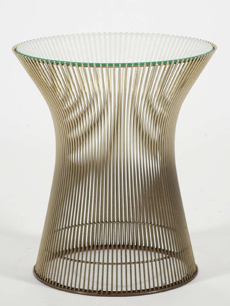 The smallest of the collection of tables Warren Platner designed for Knoll in 1966, this side table nonetheless has great visual presence. The wire rods of the base capture space, create shifting moire' patterns, and support the glass top. This