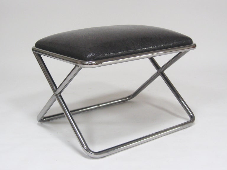 This delightful stool in the manner of Ward Bennett has a strong, simple X-form base in chrome-plated tubular steel and is topped with a seat cushion of black patent faux-snakeskin leather. The piece perfectly balances Classic modernist design with