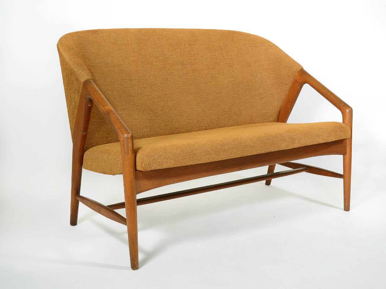 This beautiful Danish two-seat sofa with a teak frame and upholstered body is a beautiful design. It has several characteristics of designs by important Scandinavians. The manner in which the upholstered body is supported by the bearing frame