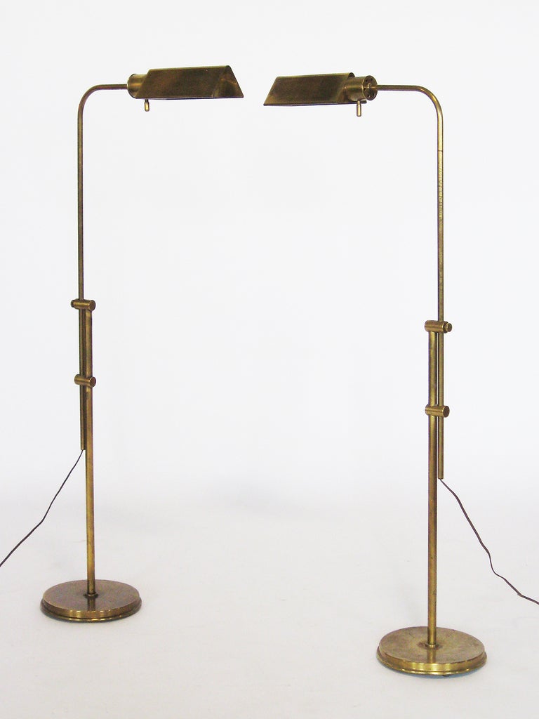 Pharmacy style floor lamps with triangular shades by Frederick Cooper. The brass has an attractive patina from age. They are adjustable in height from 35