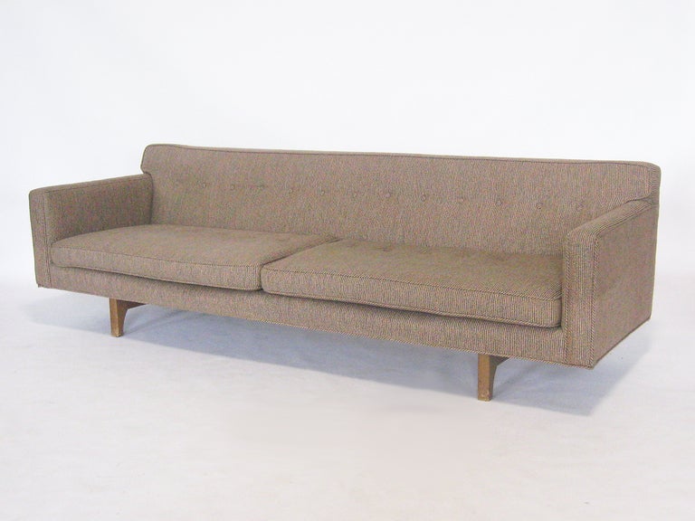 This understated sofa is one of Wormley's finest. The perfectly proportioned seat and back offer great comfort while the refined detailing includes button tufting and rear legs that extend up the back.