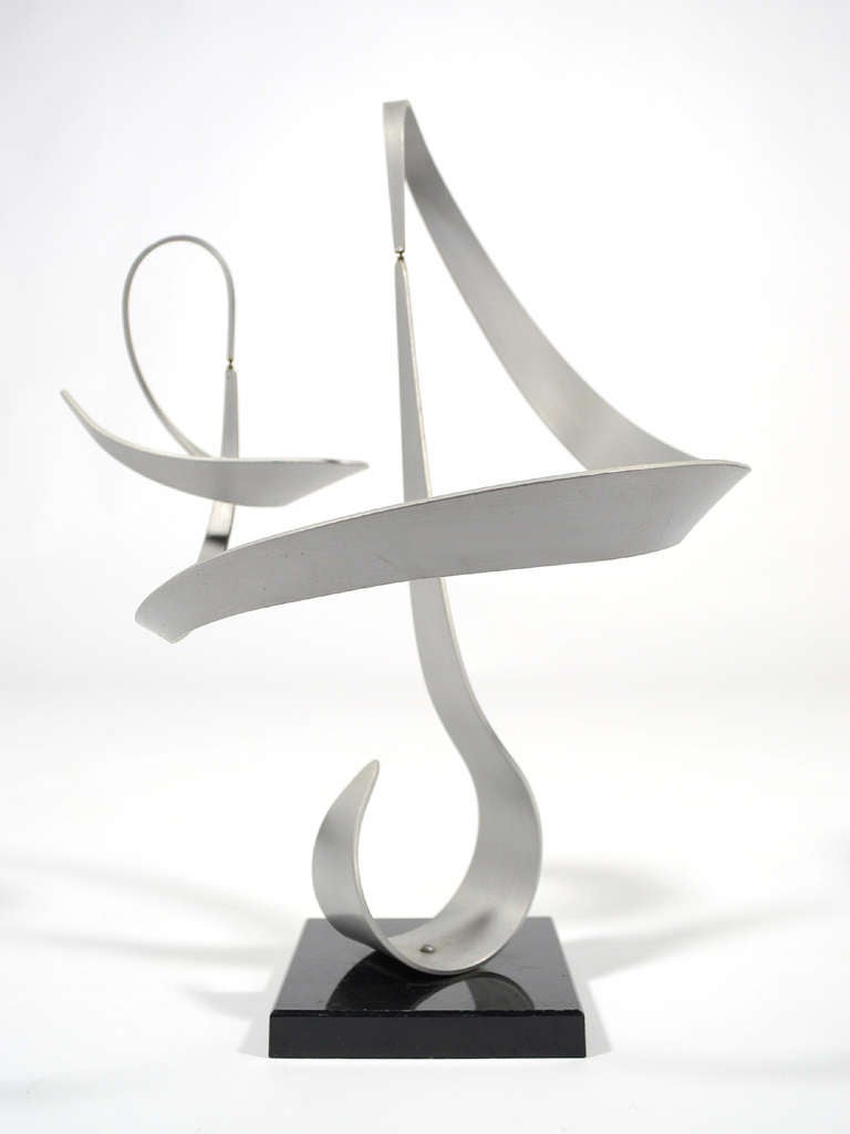 This lyrical composition by John W. Anderson has three aluminum ribbon-shaped components which will gently turn and twist with the lightest breeze. The sculpture shifts and changes as its fluid forms remain balanced in their delicate dance. 

The