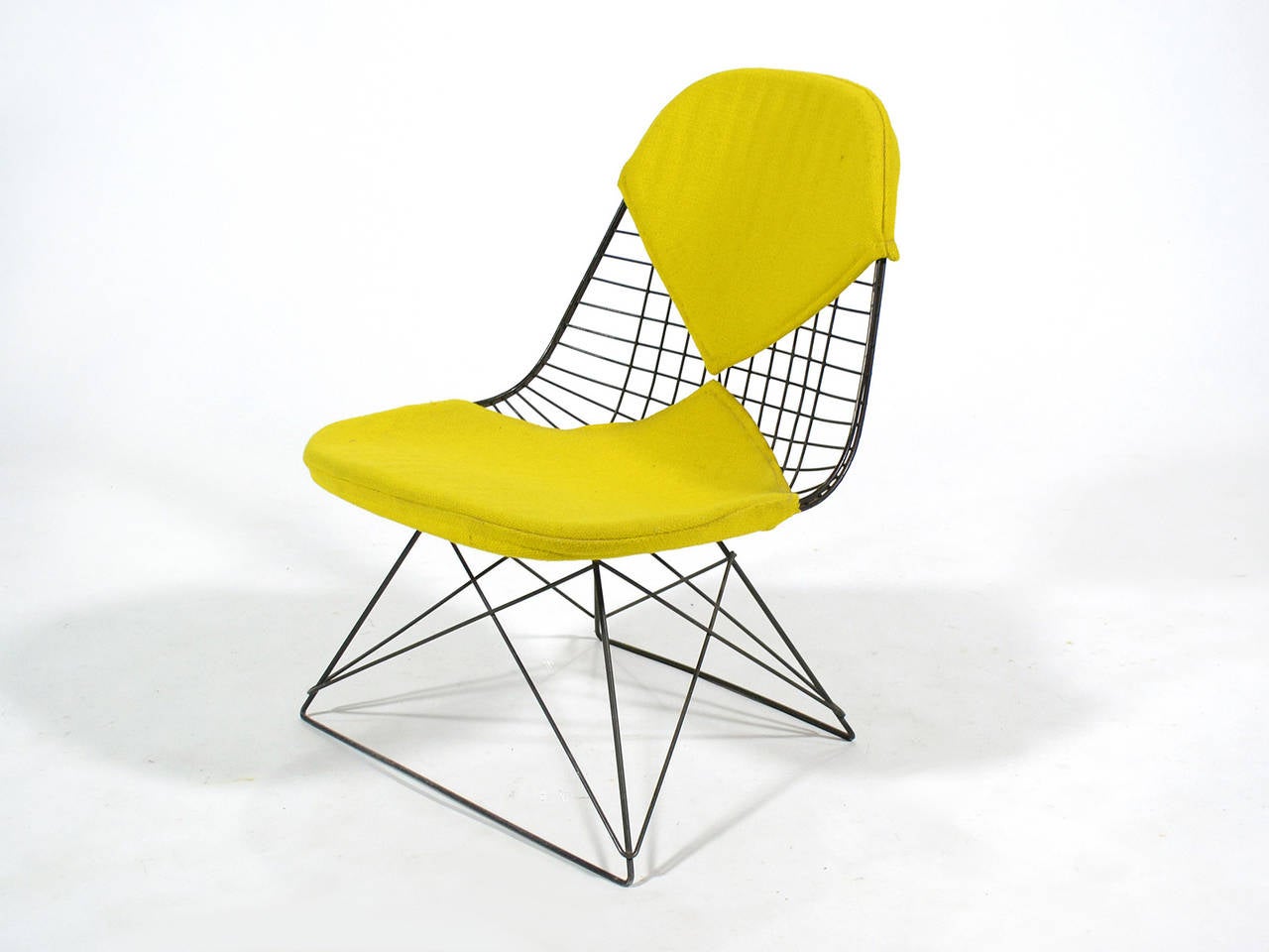 A real collector's piece, this early Eames LKR-2 wire lounge chair has a cat's cradle base and bikini pad upholstered in yellow Alexander Girard hopsack fabric. The jute backing on the seat pad dates the chair from between 1951 and 1957.
Entirely