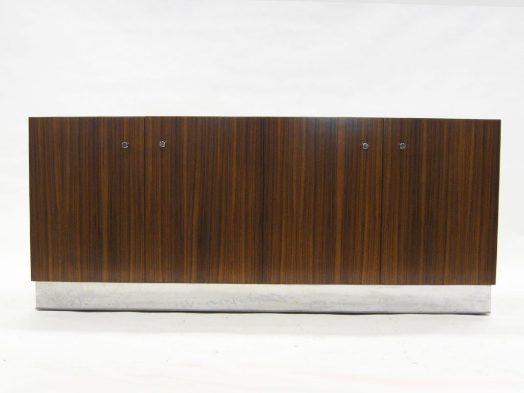 This fantastic credenza is classic Baughman. The spare form lacks any decorative embellishments, letting the exotic zebrawood veneer take center stage instead. The cabinet sits on a chrome plinth base, but is also designed to be wall mounted if
