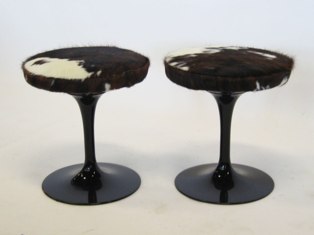 An icon of modernism, these Saarinen stools from the tulip line are upholstered in lush variegated cowhide. Combined with the black bases, they offer a strong visual presence in any room.