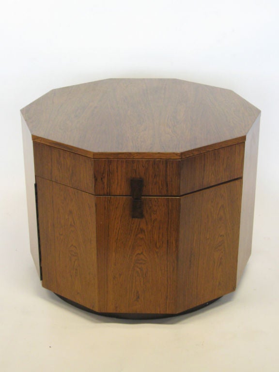 This wonderful piece by Harvey Probber offers great style and plenty of storage. The elegant form functions as a lamp table, cabinet, or dry bar with space in the drawer and also the door with built-in shelf. Both have ebonized trapezoidal handles.