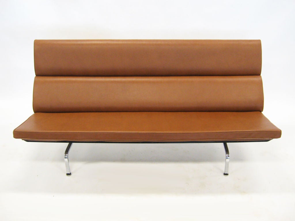 This original vintage Eames sofa compact has been upholstered in fine saddle brown leather, adding a rich color and texture to a modern classic.