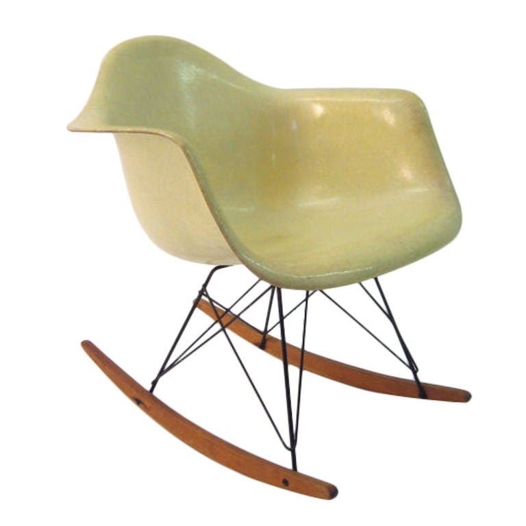 This original vintage Eames rocking chair is an early example and has desirable characteristics that later versions do not possess. 
The fiberglass shell was produced by Zenith plastics and possesses the distinctive rope edge. This embedded rope