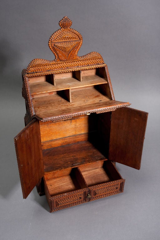 Chip Carved, Miniature Desk.  Two door cabinet over two compartment drawer.  Fanciful pediment with carved leaves, multi-layered elements on front, sides.  Soft stained, buffed finish.