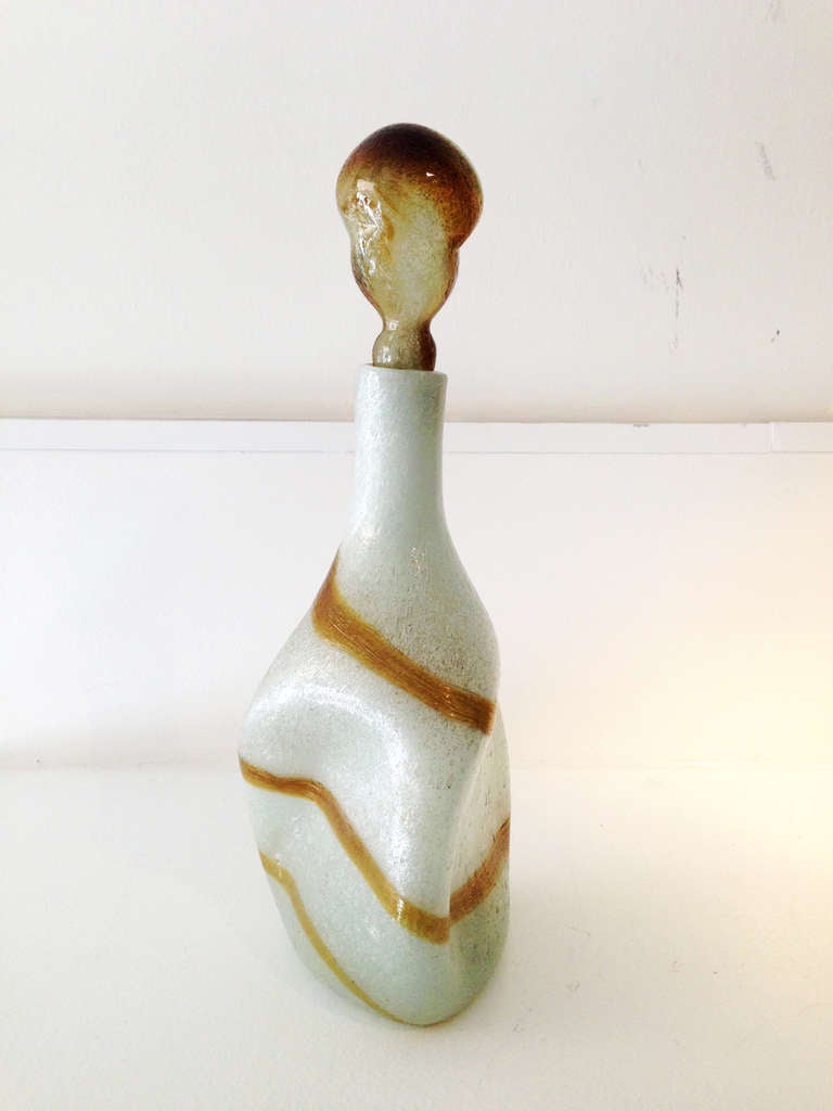 Beautifully pinched and twisted hand blown glass. White with amber swirl. Colors and stripes give it a relaxed mediterranean feel.
