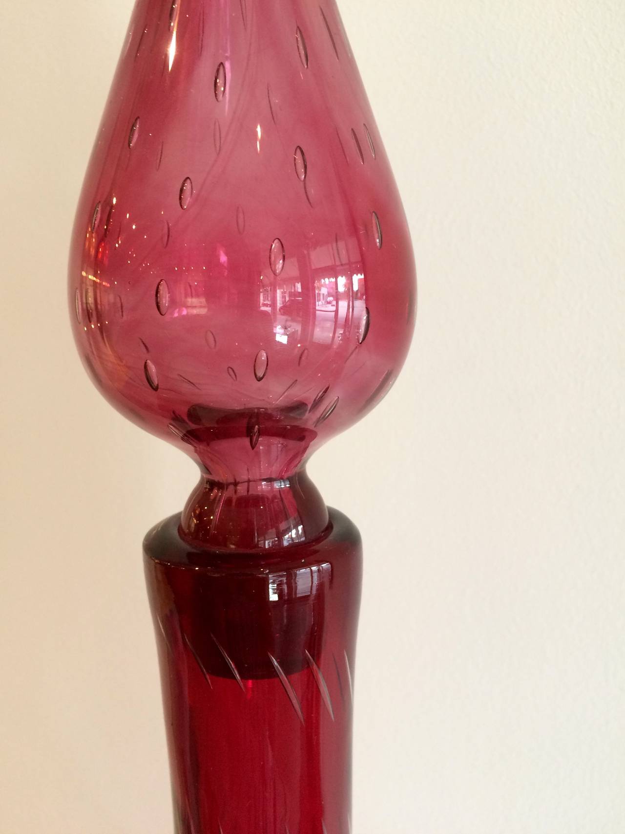 Vivid rose-colored blown glass decanter with controlled bubble pattern and pinched on each side.
