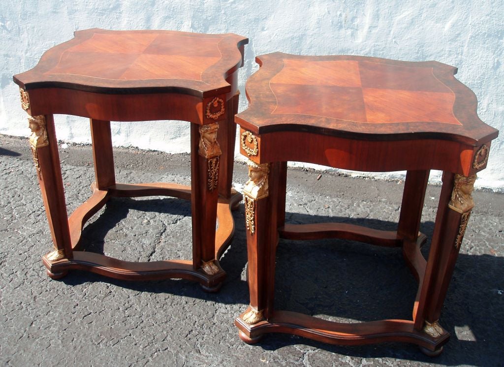 Handsome pair of Empire style polished mahogany and rosewood side tables, serpentine tops on four legged bases with carved and gilded caryotid legs and with ormolu mounts 