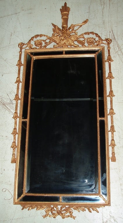 Miroir de cheminée rectangulaire de style Louis XVI en bois doré de belle facture, encadré de verre pilé et surmonté d'un carquois de piquants croisé d'une flèche et d'une branche feuillue, au-dessus de deux colombes enlacées et d'un motif en