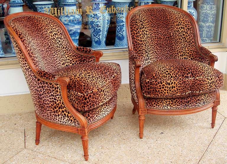 Very Chic Pair of Louis XVI Bergeres, circa 1800, Fluted Carved Wood Frames with Pitched Dome Backs, Upholstered and Padded Manchettes that terminate in Scrolling Hand Rests, Custom Upholstered with 