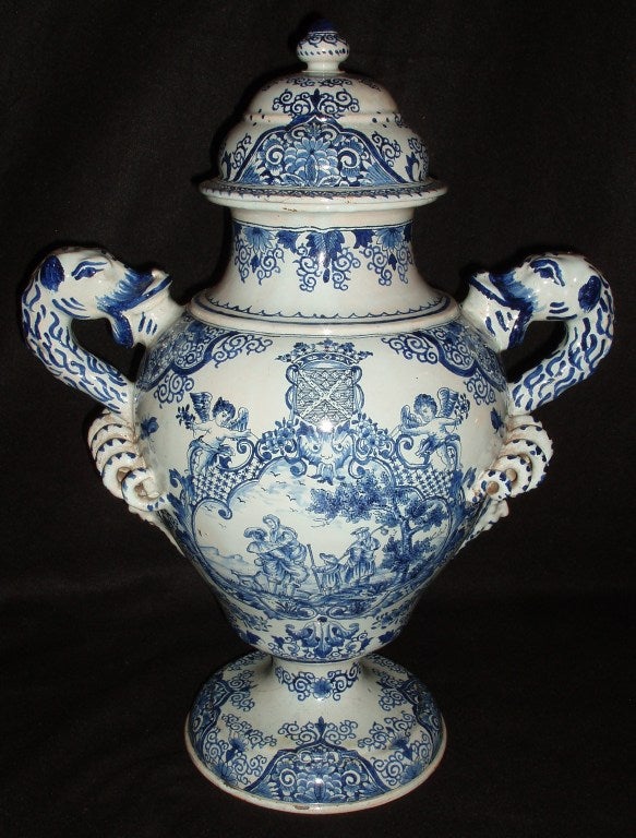 Very charming blue and white tin-glazed Villeroy & Boch baluster urn with lid, a coat of arms flanked by two putti on one side, and the reverse with a figural landscape scene within a cartouche surrounded by pierced designs, large side mounted