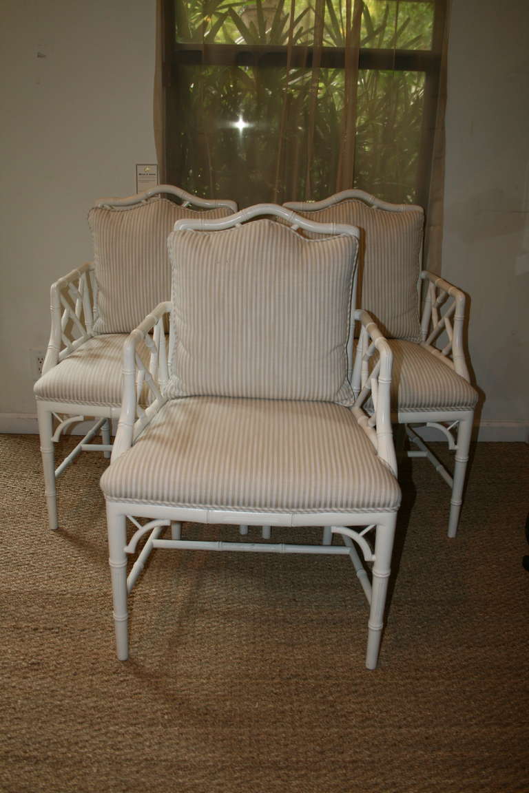 Set of three white bamboo Chippendale style armchairs with upholstered seat and back cushion.