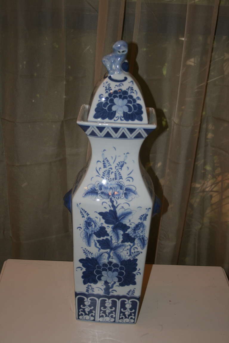 Modern Chinese porcelain tall square-form lidded jar with decorative floral designed surfaces and foo dog finial lid.