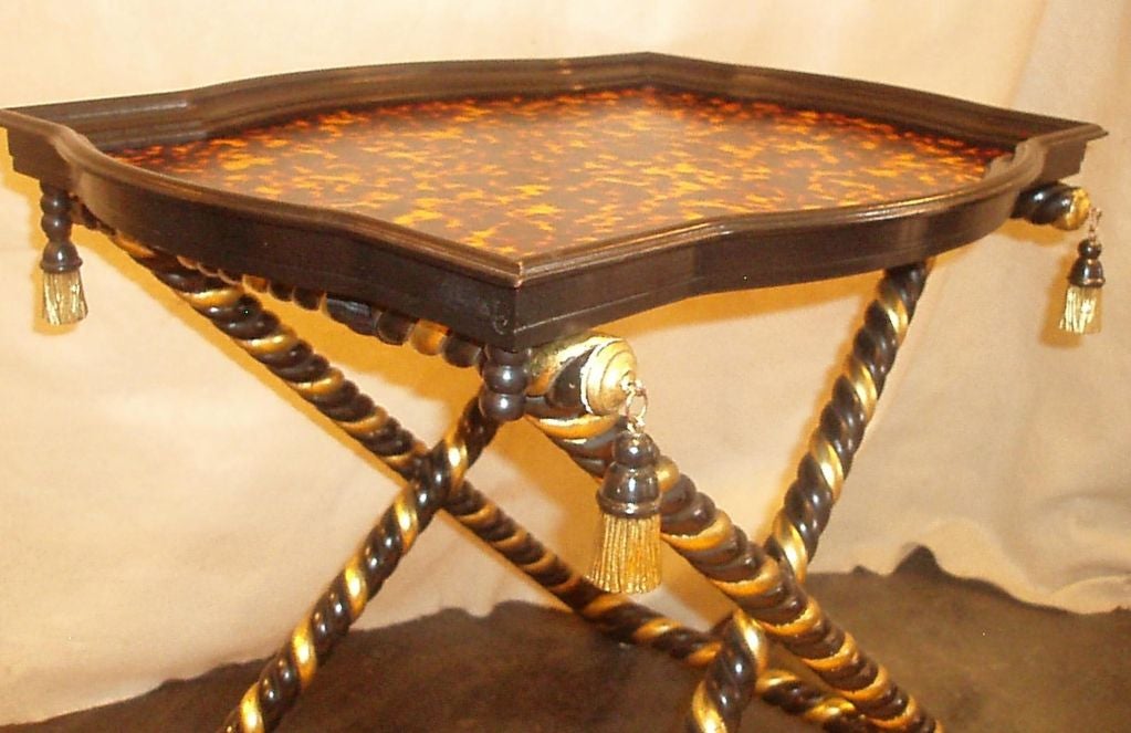 Beautifully hand finished faux tortoiseshell tray top table resting on wood carved black and gilt finished rope cross leg base with carved wood tassel corner details, Florence Italy.