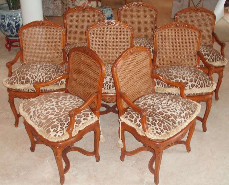 A handsome set of eight, carved and polished Louis XV style walnut dining/ armchairs with caned backs and loose fitted seat cushion in Cowtan and Tout 