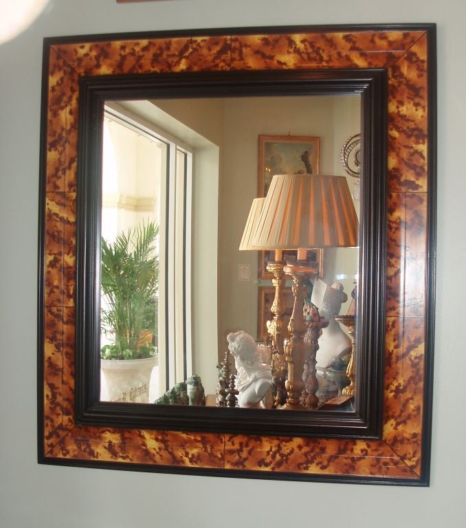 Faux tortoiseshell framed mirror with black painted molding around the sight and outer trim.
