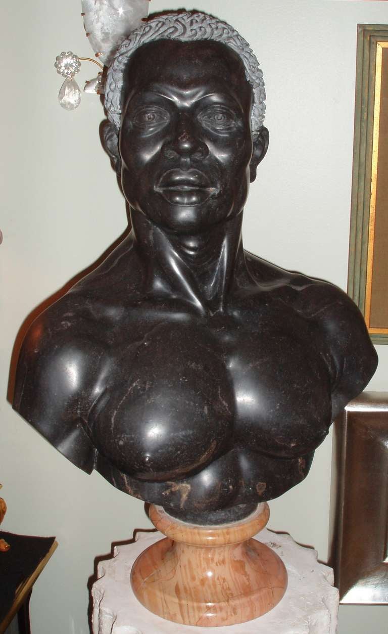 A superb hand-sculpted and polished ebony marble bust of a Nubian male on marble socle.