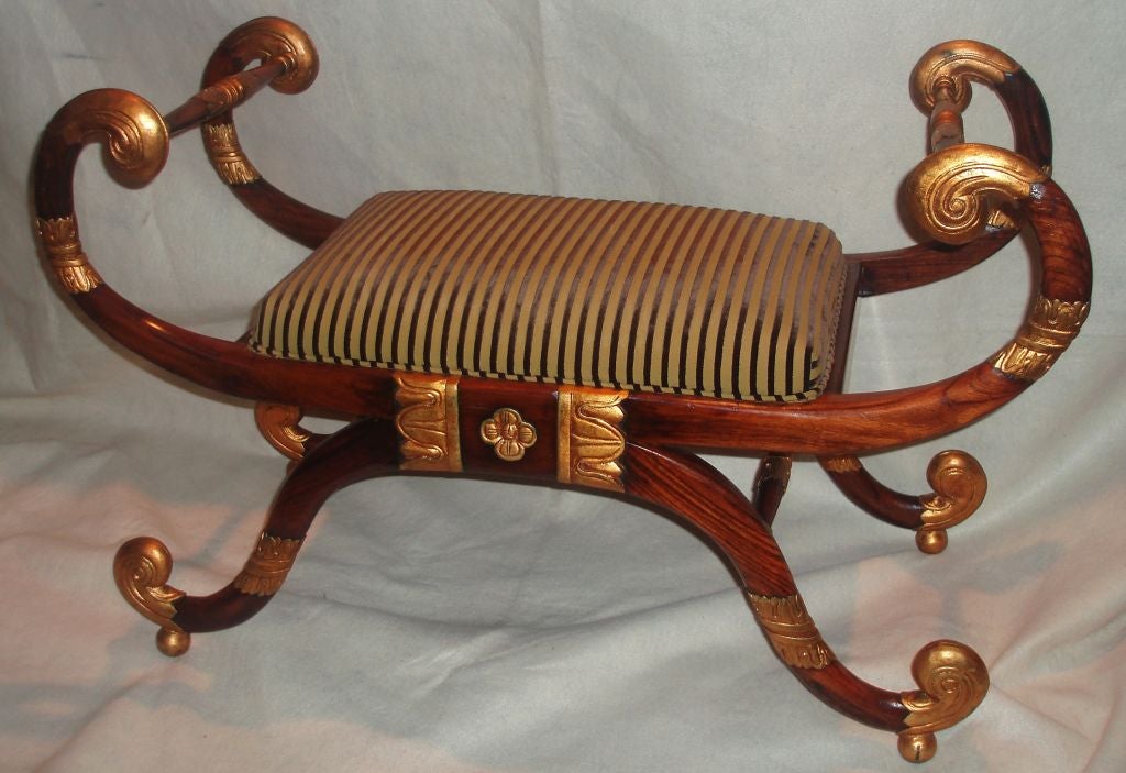 Beautifully designed Regency style carved rosewood bench with parcel-gilt details and olive green striped velvet upholstered seat.