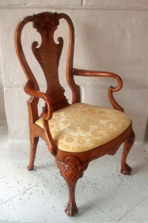 Beautifully carved and polished damask upholstered Queen Anne style burl wood armchair, acanthus leaves flanking the scrolling design on central back support with similarly detailed scrolled frame above with floral motif, rounded arm rests above