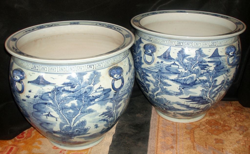 Pair of Wonderfully Detailed Blue & White Chinese Porcelain Fishbowls with Flowing Landscape & Architectural Design, Fixed Foo Dog Handles with Rings, and Greek Key Border with a Floral Design on a Flat Surfaced Rim