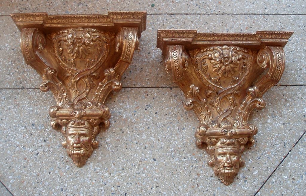 Very large carved and gilded rectangular wall brackets with well detailed decorative mountings, top with molded cornice surface above curved extensions with a central shell motif above a spiraling design flanked with plumes, above a wonderfully