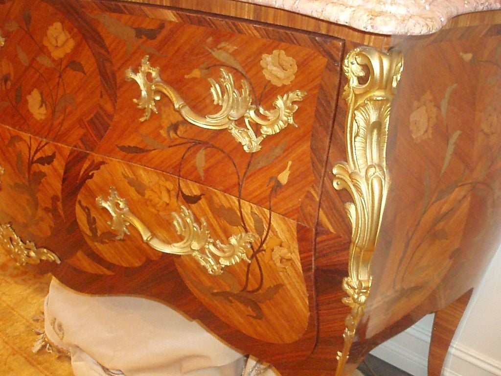 French marquetry inlaid Louis XV style bois satine', kingwood and amaranth double drawer commode showing stemmed floral entwining design with red and pink variegated marble top and bronze dore' mounts. 

Signed top of base.