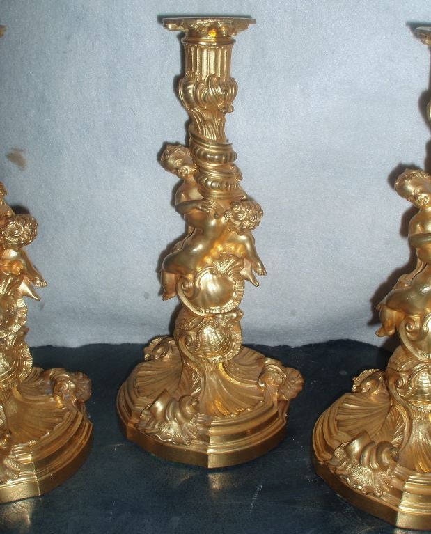 Stunning set of four French ormolu candlesticks, circa 1830.

After the Model by Meissonier,

each with a spirally-fluted and rockwork-cast central stem flanked by Entwined Puti and decorated with shells, above a conformingly cast shaped