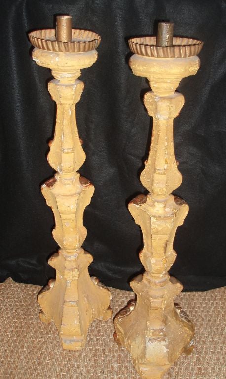Very elegant pair of carved and gilded Italian altar candlesticks with circular scallop edge bobeches set on acanthus detailed stems with three sides and finished on the front facing facades only, with gesso on the reverse.