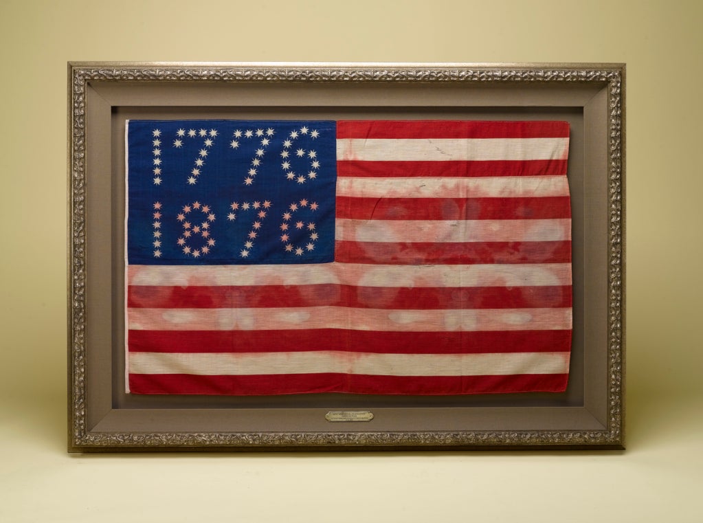 This is an extremely rare 1876 U.S. Centennial celebration parade flag design, that was popular at the Philadelphia Centennial Exhibition in 1876 and was sold in a number of different sizes, including hand-wavers, stick-flags, and full-size flags.