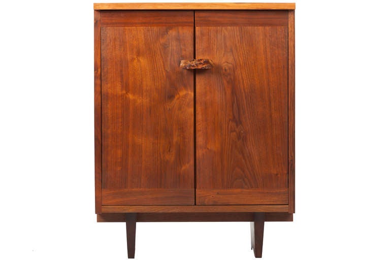 Unusual and rare oversized walnut and maple burl Kornblut cabinet.  Cabinet with dovetailed sides, free-edge over hanging top and a burled handle. Single shelf to interior. Signed with clients name.
