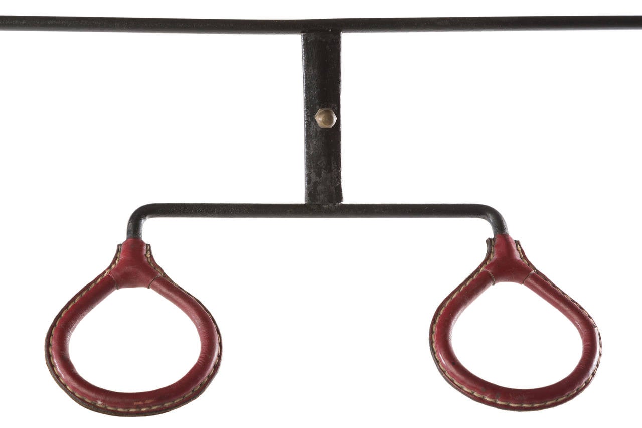 Iron and red-brown hand-stitched leather coat rack by Adnet.