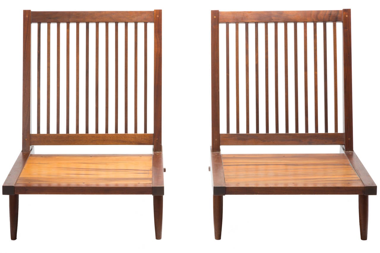 Pair of George Nakashima walnut lounge chairs circa 1965. Chairs come with older cushions that need replacing.