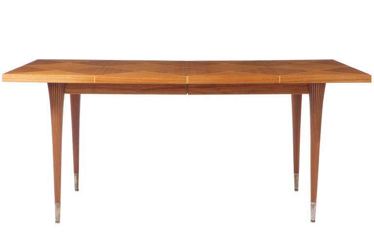 Beautiful Tommi Parzinger for Charak extension dining table in flamed mahogany with a parquetry inlaid top and fluted brass capped legs.  With two 17