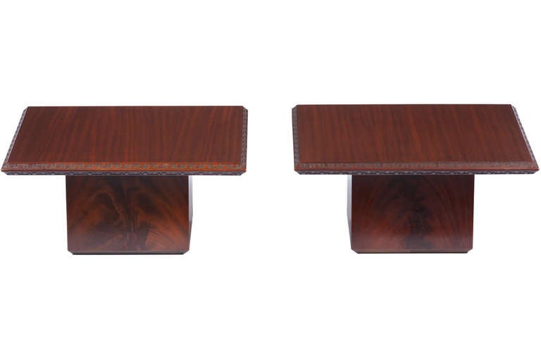 Pair of mahogany side tables designed by Frank Lloyd Wright and manufactured by Heritage Henredon Furniture. Classic Wright design with engraved Taliesin edging to perimeter.