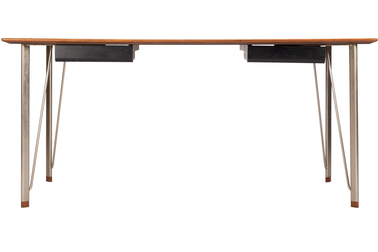 Rare minimalist desk in rosewood and steel with rosewood leg caps with 2 ebonized drawers. Model FH 3605 designed in 1955 by Arne Jacobsen and manufactured by Fritz Hansen, Denmark. Excellent restored condition.
