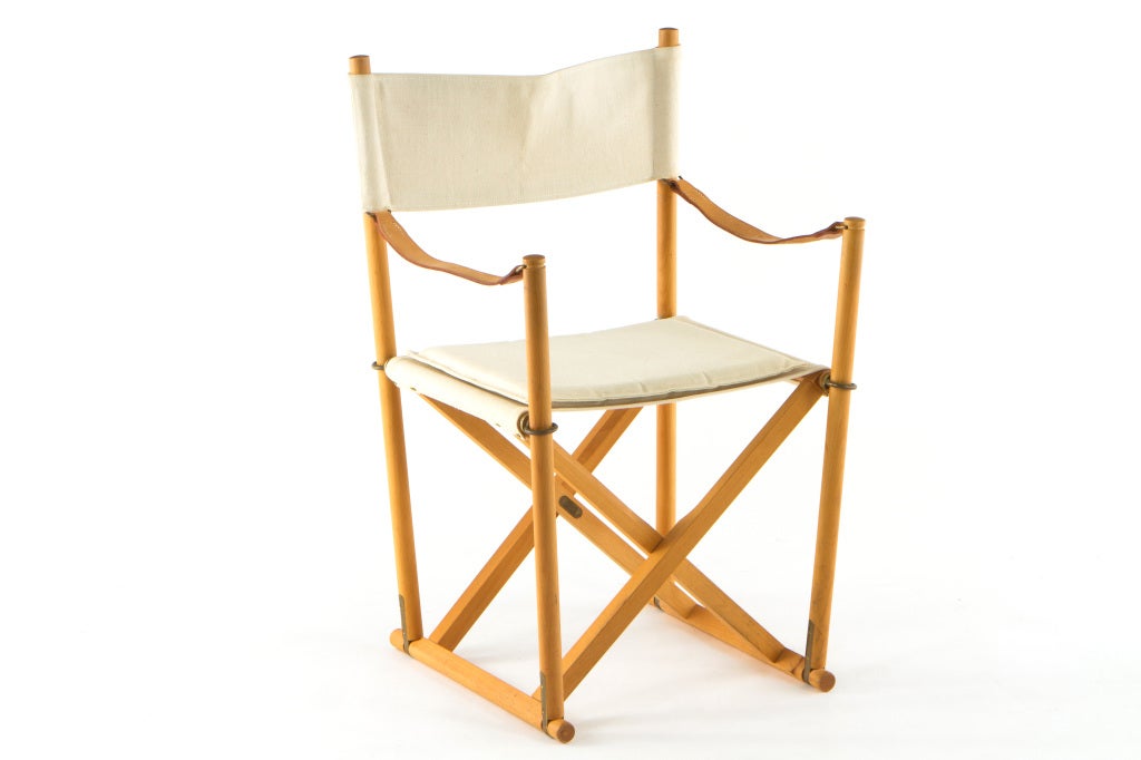 Set of 12 Mogens Koch folding chairs manufactured by Rud. Rasmussens of Denmark. Beech frames with natural canvas seats, brass fittings and stitched leather arms. Each chair has includes cushion for seat. This set dates from the 1980's.Chairs signed