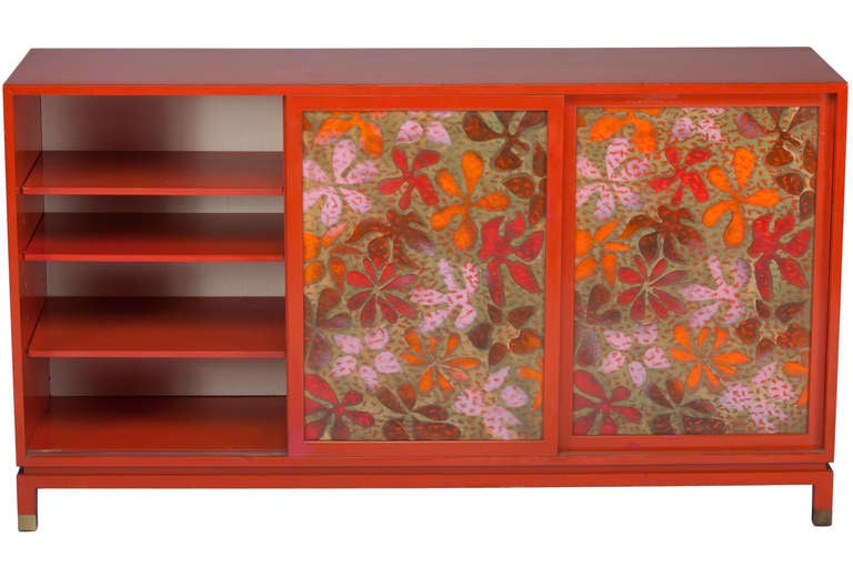 Original orange lacquered cabinet or sideboard designed by Harvey Probber. Cabinet with 3 very graphic enamel on copper sliding doors,original orange adjustable shelves ,a slide-out surface for serving and brass caps to legs.