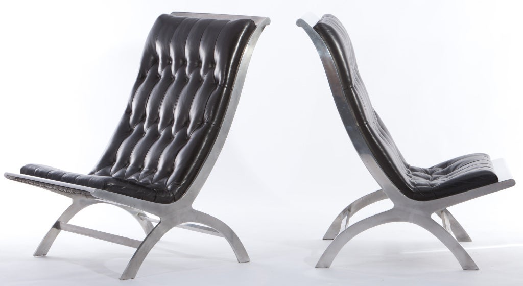 Elegant pair of lounge chairs designed by John Vesey. Polished aluminum frames and tufted leather seats with a mesh backing.