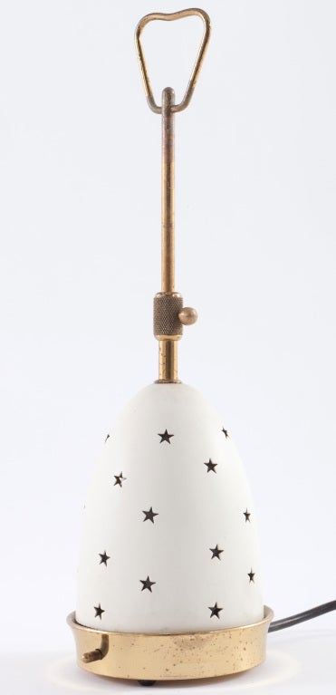Lampe de table joliment conçue par Angelo Lelli et fabriquée par Arredoluce Monza. Petite lampe avec des découpes en forme d'étoile sur un abat-jour rétractable réglable. Complète avec l'abat-jour intérieur en verre d'origine. Une lampe peu commune.