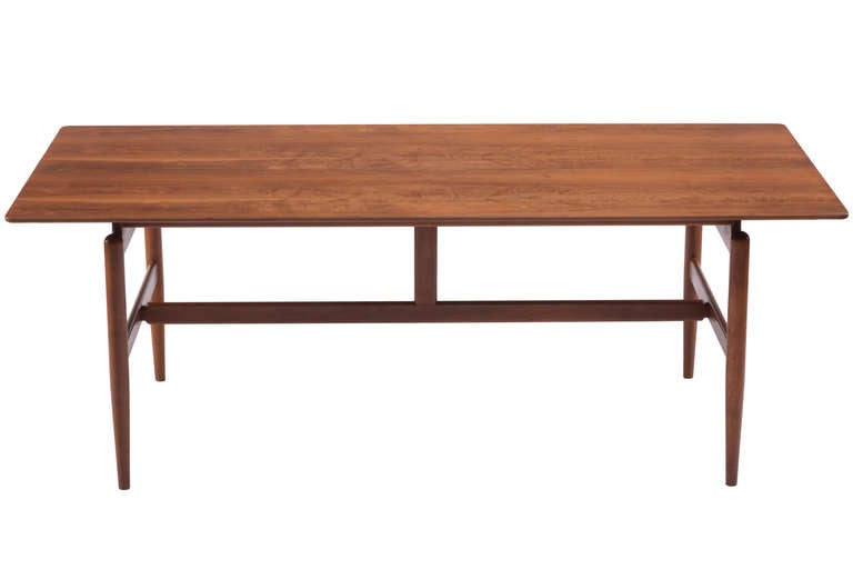 An original, early example of Finn Juhl's writing or small dining table for Baker Furniture,with a sophisticated architectural form comprising a solid teak frame and a floating walnut top with beveled edges. Originally designed in 1948, this example