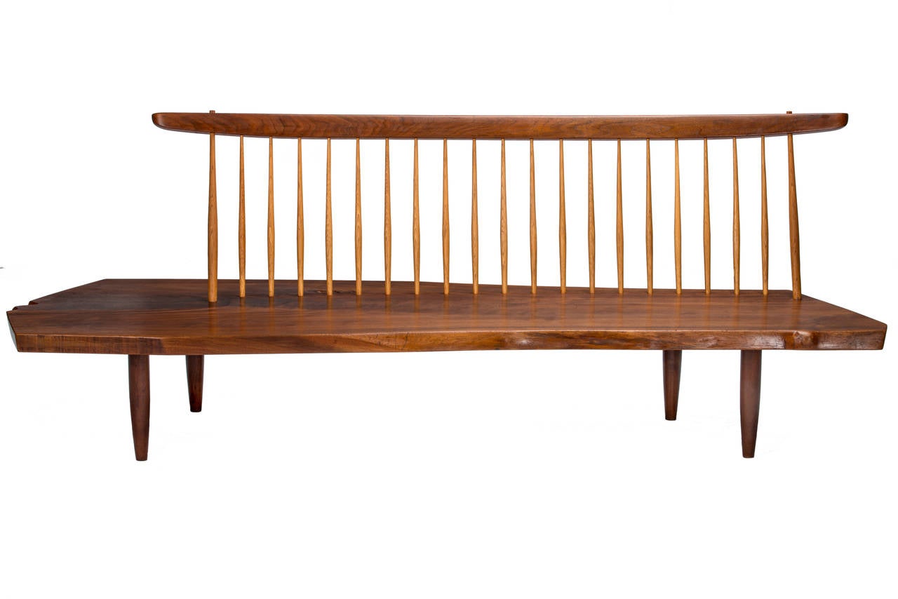 Iconic 7ft. walnut Conoid bench by George Nakashima circa 1977. Seat with a Heart-cut slab with figured-grain, two free edges and large knot. Sold with a copy of the original order card and a letter of authentication issued by Mira Nakashima.