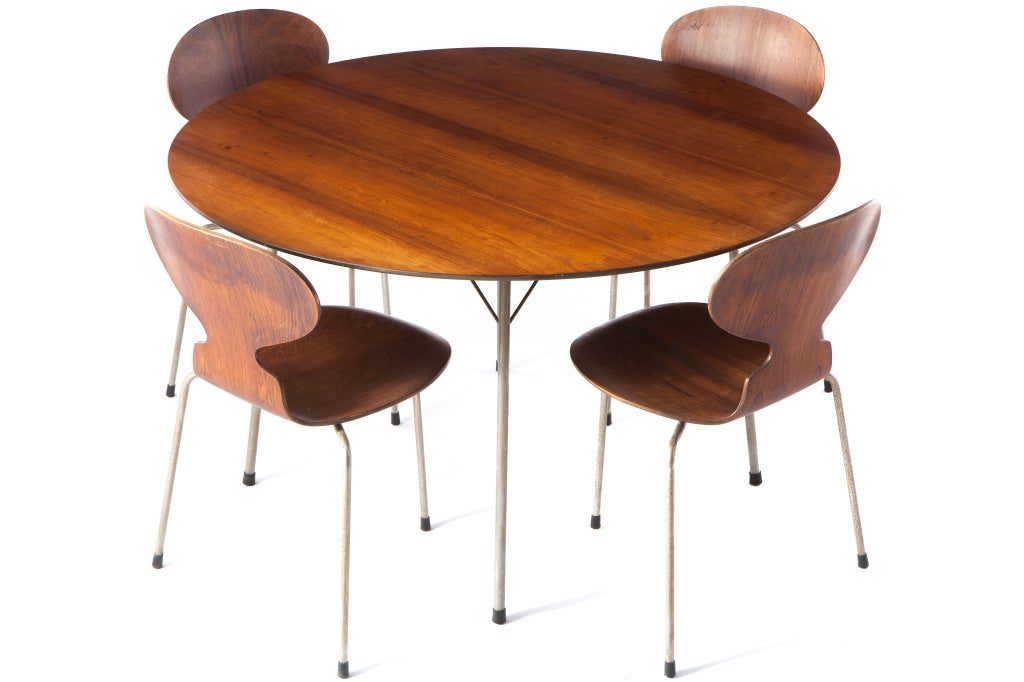 Rosewood dining set designed Arne Jacobsen and manufactured by Fritz Hansen. Early example with 3 legged ant chairs accompanying round table. Nicely figured rosewood. Some minor stains to tables top and some minor oxidation to legs.
