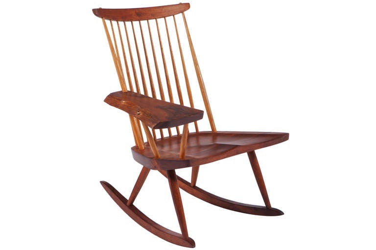 Handsome Nakashima rocker with large expressive free-edge arm. Executed in in Persian Walnut and Hickory spindles. Chair comes with provenance from Nakshima Studio. Chairs has been cleaned and oiled.