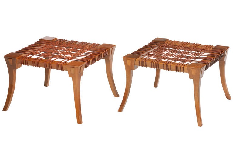 Rare and large pair of Stools or ottomans designed by T.H. Robsjohn-Gibbings and manufactured by Saridis of Athens Greece. Stools with Klismos legs and original leather seats. Signed with metal label and stamped as well.