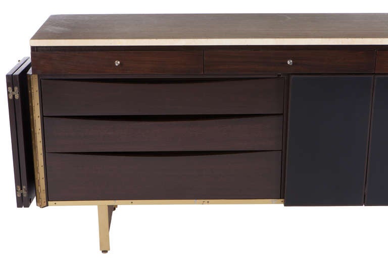 Elegant mahogany credenza designed by Paul McCobb  and manufactured by Calvin Furniture. Cabinet with 2 sets of tri-fold leather clad doors,terrazzo top and brass frame and legs. Left side of cabinet with 3 drawers,right side with shelves.Signed